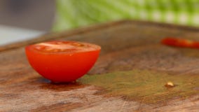 The cook cuts a tomato into slices stock video footage The cook cuts a tomato into slices stock video footage