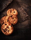 Cookies frescas dos pedaços de chocolate na tabela de madeira velha escura com lugar foto de stock Cookies frescas dos pedaços de chocolate na tabela de madeira velha escura com lugar foto de stock