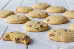 Cookies no papel do cozimento com um comido em parte foto de stock royalty free Cookies no papel do cozimento com um comido em parte foto de stock royalty free