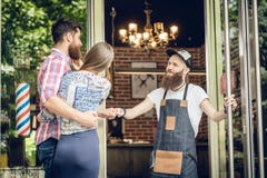 Cool hairstylist giving a fist bump to a happy customer at the door of a salon stock photography Cool hairstylist giving a fist bump to a happy customer at the door of a salon stock photography