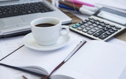 Copo de café no escritório com papéis financeiros, agenda e calculadora imagens de stock royalty free Copo de café no escritório com papéis financeiros, agenda e calculadora imagens de stock royalty free