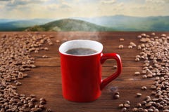 Copo vermelho do café quente em um fundo de madeira, em um fundo das montanhas Café de fumo, cozinhando imagens de stock Copo vermelho do café quente em um fundo de madeira, em um fundo das montanhas Café de fumo, cozinhando imagens de stock