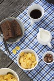 Copos de maíz sanos del desayuno, leche, taza de café sólo y torta de chocolate de la rebanada foto de archivo Copos de maíz sanos del desayuno, leche, taza de café sólo y torta de chocolate de la rebanada foto de archivo