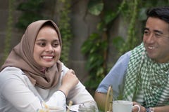 Coppia giovane musulmano avendo conversazione nel mezzo di pranzo e della prima colazione all'aperto fotografia stock libera da diritti Coppia giovane musulmano avendo conversazione nel mezzo di pranzo e della prima colazione all'aperto fotografia stock libera da diritti