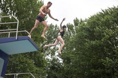 Coppia il salto da un trampolino in un nuoto fotografie stock libere da diritti Coppia il salto da un trampolino in un nuoto fotografie stock libere da diritti