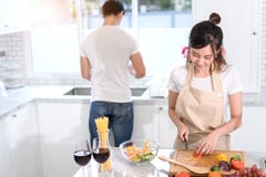 Coppia la cottura dell'alimento nella stanza della cucina, in giovane uomo asiatico ed in donna insieme immagine stock Coppia la cottura dell'alimento nella stanza della cucina, in giovane uomo asiatico ed in donna insieme immagine stock