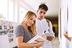 Coppie adolescenti attraenti dello studente nel corridoio della High School immagini stock libere da diritti Coppie adolescenti attraenti dello studente nel corridoio della High School immagini stock libere da diritti