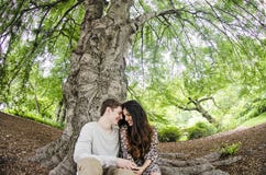 Coppie che parlano sotto un grande albero Fotografie Stock Libere da Diritti Coppie che parlano sotto un grande albero Fotografie Stock Libere da Diritti