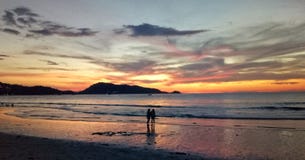 Coppie che stanno nell'ambito del tramonto fotografie stock Coppie che stanno nell'ambito del tramonto fotografie stock