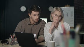 Coppie di affari che lavorano insieme al progetto finanziario in ufficio scuro stock footage Coppie di affari che lavorano insieme al progetto finanziario in ufficio scuro stock footage