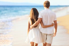 Coppie di vacanza che camminano sulla spiaggia