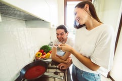 Coppie felici nell'amore divertendosi cucinando togheter a casa fotografia stock libera da diritti Coppie felici nell'amore divertendosi cucinando togheter a casa fotografia stock libera da diritti