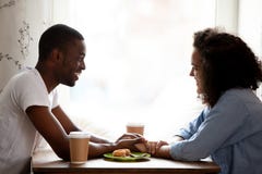 Coppie multirazziali felici che si tengono per mano, godendo della data in caffè immagine stock libera da diritti Coppie multirazziali felici che si tengono per mano, godendo della data in caffè immagine stock libera da diritti
