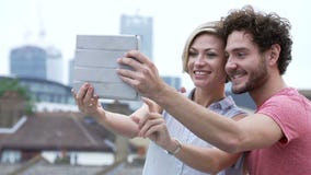 Coppie nell'ambiente urbano con la compressa di Digital che prende foto stock footage Coppie nell'ambiente urbano con la compressa di Digital che prende foto stock footage