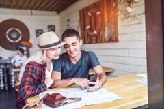 Coppie in self-service facendo uso dello smartphone mentre viaggiando immagine stock Coppie in self-service facendo uso dello smartphone mentre viaggiando immagine stock