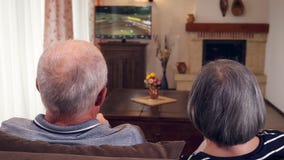 Coppie senior che si siedono insieme sulla televisione di sorveglianza del sofà video d archivio Coppie senior che si siedono insieme sulla televisione di sorveglianza del sofà video d archivio