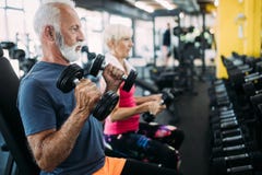 Coppie sportive senior adatte che risolvono insieme alla palestra fotografia stock libera da diritti Coppie sportive senior adatte che risolvono insieme alla palestra fotografia stock libera da diritti