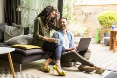 Coppie sveglie felici nell'amore con il caffè e lo smili beventi del computer portatile immagine stock libera da diritti Coppie sveglie felici nell'amore con il caffè e lo smili beventi del computer portatile immagine stock libera da diritti