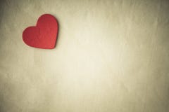 Corazón decorativo de madera rojo en fondo del paño. Tono de la sepia imágenes de archivo libres de regalías Corazón decorativo de madera rojo en fondo del paño. Tono de la sepia imágenes de archivo libres de regalías