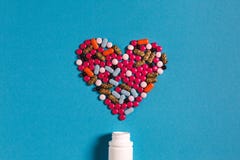 Corazón del símbolo del medicamento de las píldoras del color en fondo azul Concepto de la medicina de la creatividad imágenes de archivo libres de regalías Corazón del símbolo del medicamento de las píldoras del color en fondo azul Concepto de la medicina de la creatividad imágenes de archivo libres de regalías