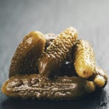 Cornichons adobados en tablero de la pizarra Imágenes de archivo libres de regalías Cornichons adobados en tablero de la pizarra Imágenes de archivo libres de regalías