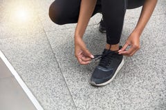 Corredor fêmea que amarra as sapatas que preparam-se para uma corrida imagens de stock Corredor fêmea que amarra as sapatas que preparam-se para uma corrida imagens de stock