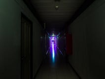 Corridoio misterioso scuro in costruzione Prospettiva della stanza della porta in costruzione con luce viola, concetto di orrore fotografia stock Corridoio misterioso scuro in costruzione Prospettiva della stanza della porta in costruzione con luce viola, concetto di orrore fotografia stock