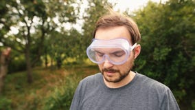 Cortacésped joven que lleva la protección transparente de los vidrios y y que aísla los auriculares metrajes Cortacésped joven que lleva la protección transparente de los vidrios y y que aísla los auriculares metrajes