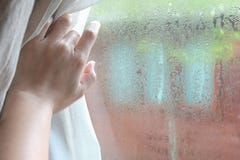 Cortinas de abertura de la mano de la mujer en el dormitorio con la gotita de la lluvia en la luz de cristal, natural y el fondo imágenes de archivo libres de regalías Cortinas de abertura de la mano de la mujer en el dormitorio con la gotita de la lluvia en la luz de cristal, natural y el fondo imágenes de archivo libres de regalías