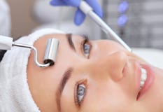The cosmetologist makes the apparatus a procedure of Microcurrent therapy of a beautiful, young woman in a beauty salon. royalty free stock images The cosmetologist makes the apparatus a procedure of Microcurrent therapy of a beautiful, young woman in a beauty salon. royalty free stock images