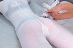 Cosmetologist makes a woman in nylon suit lpg massage booty, legs, body. stock image Cosmetologist makes a woman in nylon suit lpg massage booty, legs, body. stock image