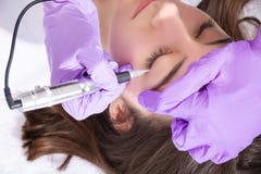 Cosmetologist robi sta?emu elementowi uzupe?nia? eyeliner na pi?knej m?odej dziewczynie w pi?kna studiu zdjęcie royalty free Cosmetologist robi sta?emu elementowi uzupe?nia? eyeliner na pi?knej m?odej dziewczynie w pi?kna studiu zdjęcie royalty free