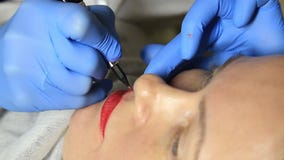 Cosmetologist που εφαρμόζει τη μόνιμη σύνθεση Νέα όμορφη γυναίκα που έχει την καλλυντική δερματοστιξία στα χείλια της υγιής SPA φιλμ μικρού μήκους Cosmetologist που εφαρμόζει τη μόνιμη σύνθεση Νέα όμορφη γυναίκα που έχει την καλλυντική δερματοστιξία στα χείλια της υγιής SPA φιλμ μικρού μήκους