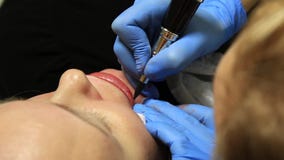 Cosmetologist που εφαρμόζει τη μόνιμη σύνθεση Νέα όμορφη γυναίκα που έχει την καλλυντική δερματοστιξία στα χείλια της υγιής SPA απόθεμα βίντεο Cosmetologist που εφαρμόζει τη μόνιμη σύνθεση Νέα όμορφη γυναίκα που έχει την καλλυντική δερματοστιξία στα χείλια της υγιής SPA απόθεμα βίντεο