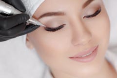 Cosmetologist που κάνει μόνιμο να αποτελέσει στο σαλόνι ομορφιάς στοκ εικόνα Cosmetologist που κάνει μόνιμο να αποτελέσει στο σαλόνι ομορφιάς στοκ εικόνα