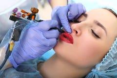 Cosmetologist που κάνει το μόνιμο makeup στο πρόσωπο της γυναίκας στοκ φωτογραφία με δικαίωμα ελεύθερης χρήσης Cosmetologist που κάνει το μόνιμο makeup στο πρόσωπο της γυναίκας στοκ φωτογραφία με δικαίωμα ελεύθερης χρήσης
