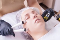 Cosmetologist делает процедуру по прибора терапии красивого, молодой женщины Microcurrent в салоне красоты стоковое фото Cosmetologist делает процедуру по прибора терапии красивого, молодой женщины Microcurrent в салоне красоты стоковое фото