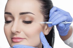 Cosmetologist доктора делает Rejuvenating лицевую процедуру по впрысок для затягивать и приглаживать морщинки на коже стороны Стоковое Фото Cosmetologist доктора делает Rejuvenating лицевую процедуру по впрысок для затягивать и приглаживать морщинки на коже стороны Стоковое Фото