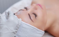 Cosmetologist доктора делает Rejuvenating лицевую процедуру по впрысок для затягивать и приглаживать морщинки Стоковое Изображение RF Cosmetologist доктора делает Rejuvenating лицевую процедуру по впрысок для затягивать и приглаживать морщинки Стоковое Изображение RF