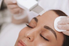 Cosmetologist прекрасной молодой женщины посещая на клинике красоты стоковое фото Cosmetologist прекрасной молодой женщины посещая на клинике красоты стоковое фото