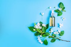 Cosméticos orgânicos naturais no fundo azul em um quadro das flores, árvore de maçã de florescência foto de stock royalty free Cosméticos orgânicos naturais no fundo azul em um quadro das flores, árvore de maçã de florescência foto de stock royalty free