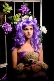 Cosplay flicka i purpurfärgad peruk med leksaken och blommor fotografering för bildbyråer Cosplay flicka i purpurfärgad peruk med leksaken och blommor fotografering för bildbyråer