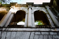 Costruzione abbandonata con le colonne e le finestre incurvate fotografia stock libera da diritti Costruzione abbandonata con le colonne e le finestre incurvate fotografia stock libera da diritti