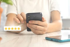 Costumer reviews concept with rating or feedback icon, gold five star review the service, woman with smartphone