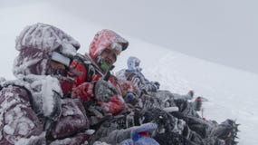 Group of climbers freezing at the summit of the Cotopaxi volcano while waiting for the snowstorm to pass to begin to descend royalty free stock image Group of climbers freezing at the summit of the Cotopaxi volcano while waiting for the snowstorm to pass to begin to descend royalty free stock image