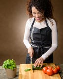 Cottura felice della donna Alimento sano - cetriolo fresco immagini stock Cottura felice della donna Alimento sano - cetriolo fresco immagini stock