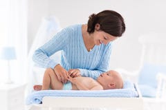 Couche-culotte changeante de mère au bébé garçon Images libres de droits Couche-culotte changeante de mère au bébé garçon Images libres de droits