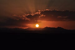 Coucher du soleil au-dessus des montagnes avec le soleil brillant par les nuages photos libres de droits Coucher du soleil au-dessus des montagnes avec le soleil brillant par les nuages photos libres de droits