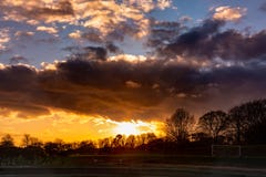 Coucher du soleil dramatique au-dessus de terrain de football photographie stock libre de droits Coucher du soleil dramatique au-dessus de terrain de football photographie stock libre de droits