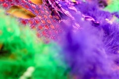 Couleur intense - fond de Mardi Gras - de Carnaval dans pourpre et vert - plumes brouillées et un masque sur le fond d'or photo stock Couleur intense - fond de Mardi Gras - de Carnaval dans pourpre et vert - plumes brouillées et un masque sur le fond d'or photo stock